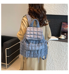 Close-up of light blue quilted bubble texture backpack with drawstring and flap closure