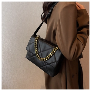 Détail du sac bandoulière matelassé noir avec chaîne dorée et finition en cuir mat