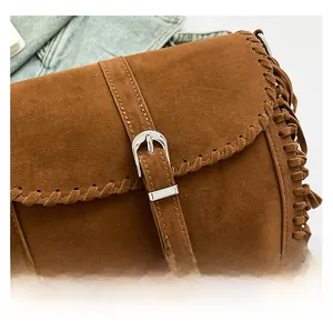 Dettaglio ravvicinato della borsa in pelle scamosciata marrone con frange e fibbia argento