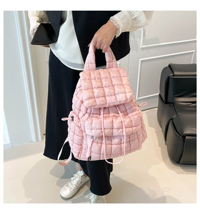 Detailed view of pink quilted puff backpack with texture and drawstring side pockets