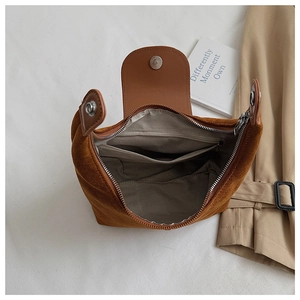 Détail de l'intérieur du sac en daim avec doublure à chevrons gris et poche zippée