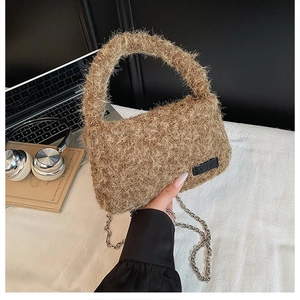 Detail of brown plush crossbody bag with curl faux fur texture and elegant chain strap