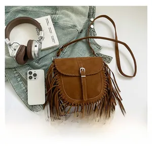 Dettagli della borsa a sella boho in camoscio marrone con frange e bordi intrecciati