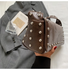 Vue détaillée du sac en similicuir marron foncé avec rivets et style industriel rétro