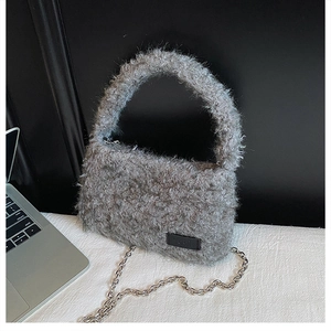 Detail of grey plush handbag featuring faux lamb fur texture and silver metal chain strap