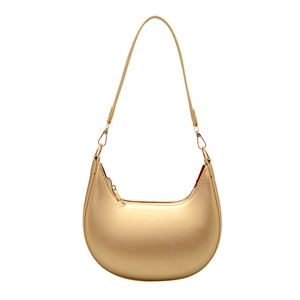 Metallic gold crescent shoulder bag with zipper closure and slim strap on white background