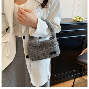 Close-up of grey plush handbag featuring soft faux fur texture and silver metal chain strap
