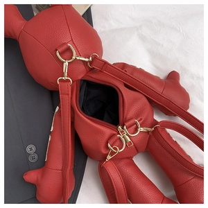 Close-up of red bear-shaped crossbody bag with gold hardware and zipper detail