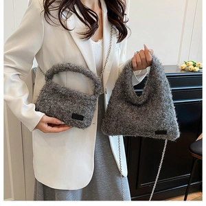 Detail of grey plush handbag featuring soft faux fur texture and silver metal chain strap