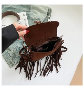 Dettaglio della borsa a sella in pelle scamosciata marrone con tasca e frange chic