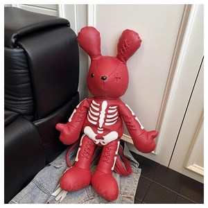 Close-up of red leather bunny backpack featuring stitched white skeleton bone patterns