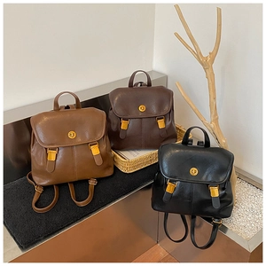 Detailed close-up of retro backpacks in caramel, dark brown, and black with gold buckles