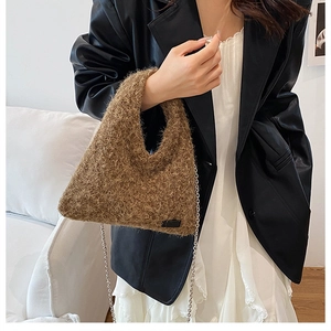 Close-up of fluffy brown plush handbag featuring detailed texture and gold metal chain strap