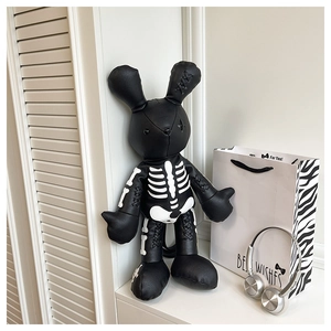 Detail of gothic rabbit plush with white skeleton print and stitched ear details