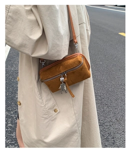 Detail of brown faux suede crossbody bag with a cute silver robot zipper charm