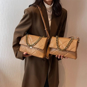 Sac à main matelassé marron avec chaîne dorée en deux tailles porté par un mannequin