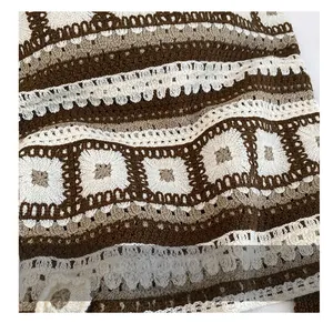 Detail of vintage crochet knit fabric showing brown and beige floral geometric patterns