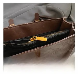 Detail shot of golden metal zipper and magnetic buckle on brown leather backpack