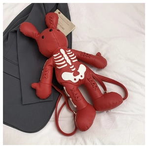 Detail of red rabbit backpack with white skeleton design and golden metal hardware