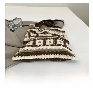 Detail of bohemian knit tote bag showing brown geometric crochet patterns and texture