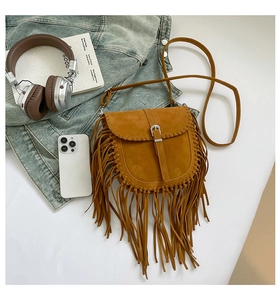Dettaglio della borsa a sella in pelle scamosciata boho con bordi intrecciati e frange