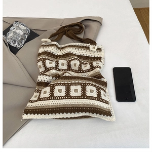 Detail of bohemian knit tote bag with geometric patterns and soft brown handles