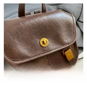 Detail of vintage brown leather backpack with gold Roman numeral twist lock closure