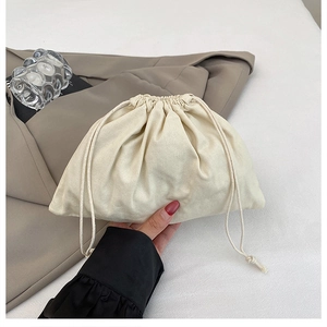 Detail view of cream drawstring bucket bag showing natural cotton linen texture and folds