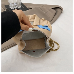 Detail of creative jacket-shaped mini bag with chain strap showing grey suede inner lining