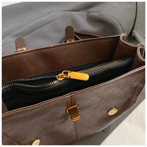 Detailed interior of vintage brown PU leather backpack with black lining and gold zipper