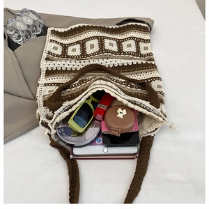 Detail showing spacious interior of knit crochet tote bag with sunglasses and cosmetics