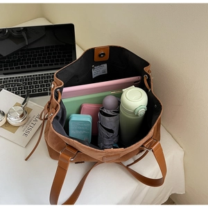 Detail shot of a large brown suede tote bag showing its spacious interior capacity