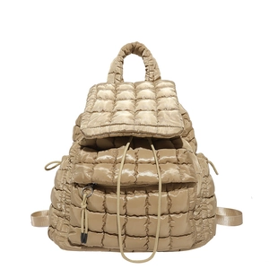Quilted champagne gold puffer backpack with stylish drawstrings and top handle