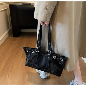 Detail showing distressed black leather texture with silver metal eyelets on the tote bag