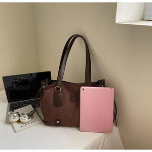 Detail of vintage matte tote bag showing large capacity next to office tech gadgets