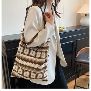 Close-up of bohemian knitted crochet tote bag with geometric patterns and thick shoulder strap