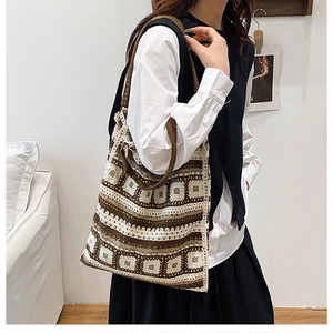 Close-up of handcrafted knit tote bag with brown floral patterns and wide shoulder strap
