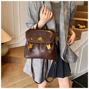 Brown vintage PU leather backpack with gold twist lock shown on model's shoulder