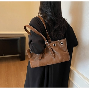 Vue arrière d'un mannequin portant un sac cabas marron vintage aux détails d'œillets