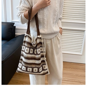 Detail of vintage hand-crocheted tote bag featuring brown and cream floral patterns
