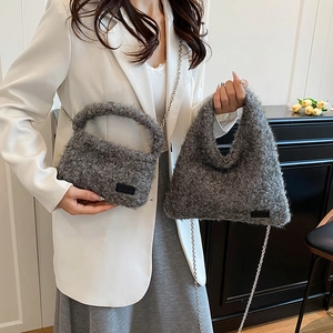 Elegant grey plush crossbody bag with silver chain strap shown in a modern interior setting