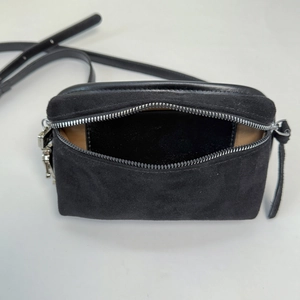 Detailed top view of black suede crossbody bag with zipper and internal card slot