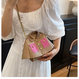 Close-up of creative jacket-shaped brown leather bag with pink pockets and gold chain strap