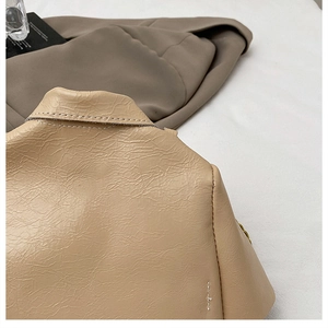 Macro shot of stitching details and texture on beige leather crossbody chain bag