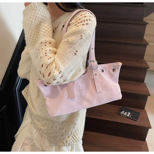 Détail du sac cabas en suédine rose avec œillets argentés et bandoulière réglable