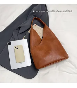 Comparación de tamaño del bolso de cuero marrón con tableta y móvil sobre fondo de chaqueta
