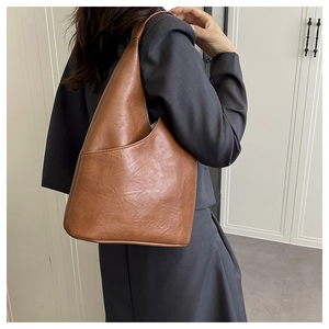 Vista detallada del bolso tote marrón caramelo con textura de cuero plisado vintage