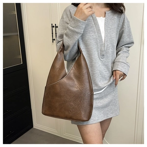Primer plano detallado de un bolso hobo vintage de cuero PU marrón con textura de pliegues