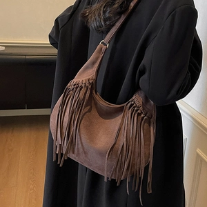 Gros plan du sac hobo en daim marron foncé avec de longues franges bohèmes