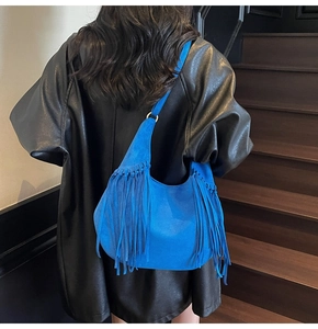 Détail du sac hobo en daim bleu vif avec de longues franges et des anneaux en métal